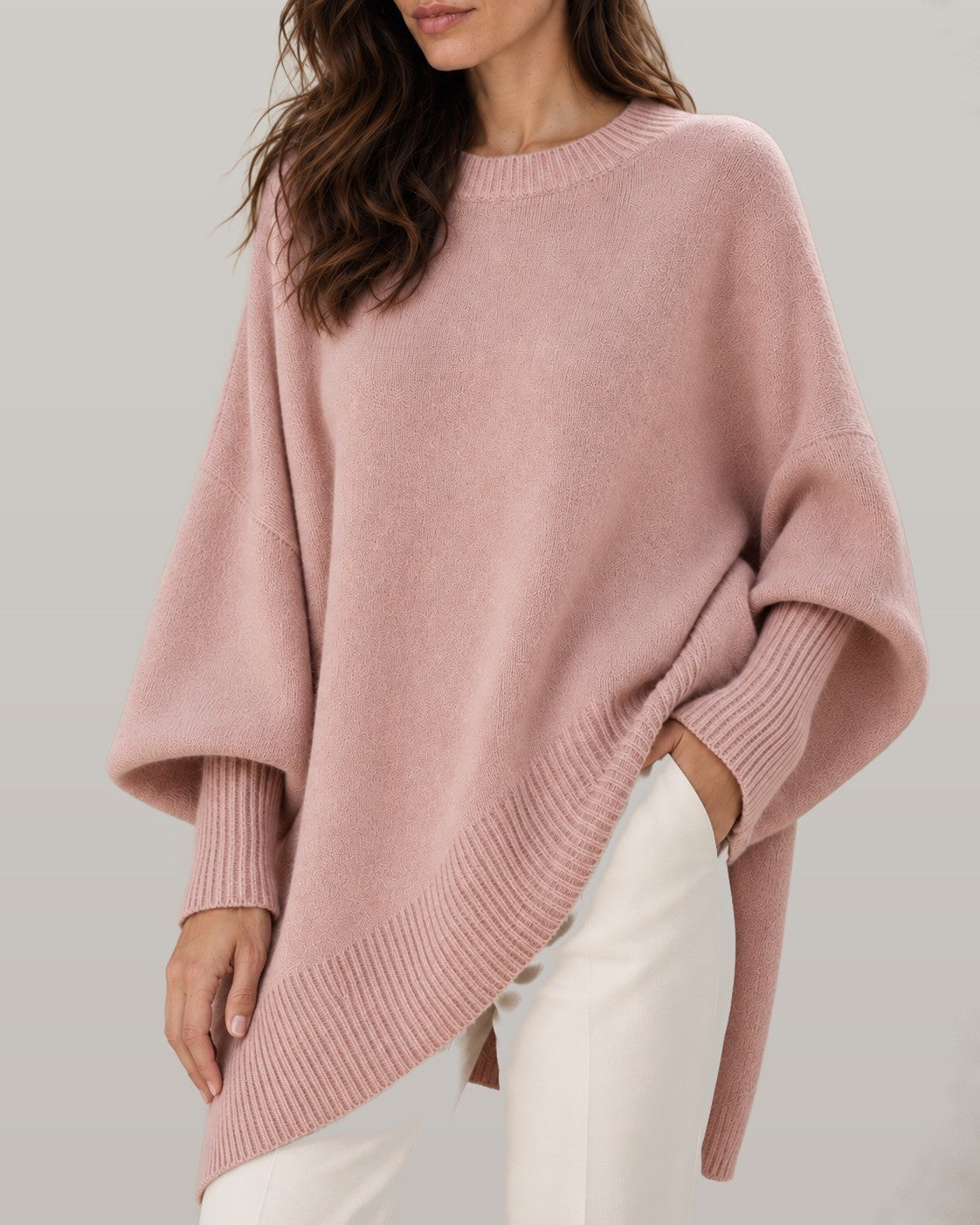 Draped asymmetric knit poncho in pink, close-up detail