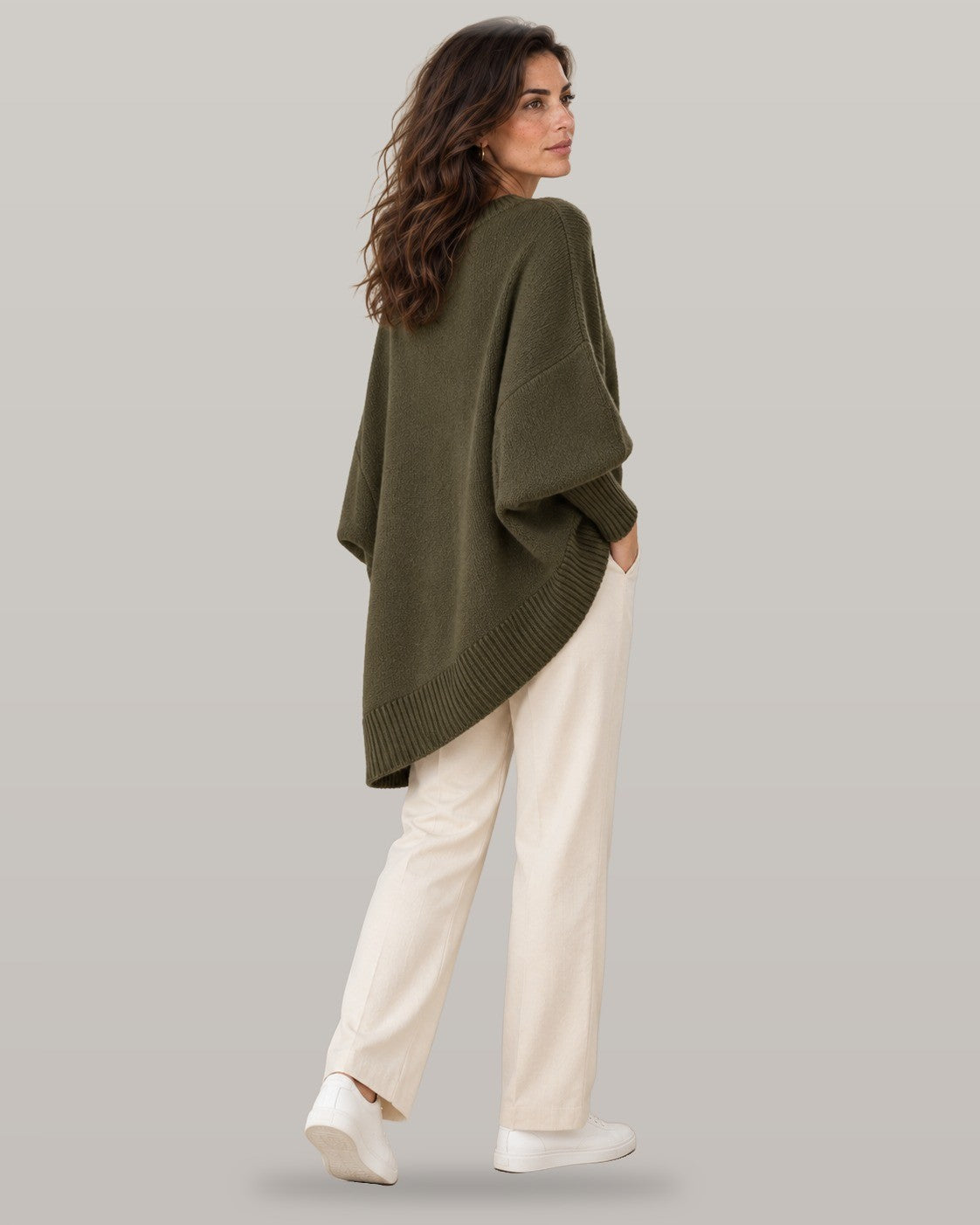 Draped asymmetric knit poncho in dark green, back view